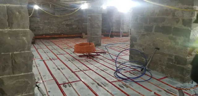 Radiant floor heating system components are neatly arranged on a layer of insulation material