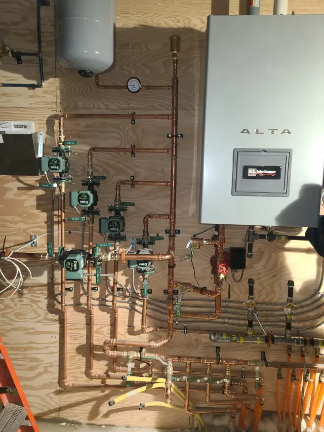 An image of an Alta boiler, equipped with a pressure relief valve and an expansion tank, installed on
