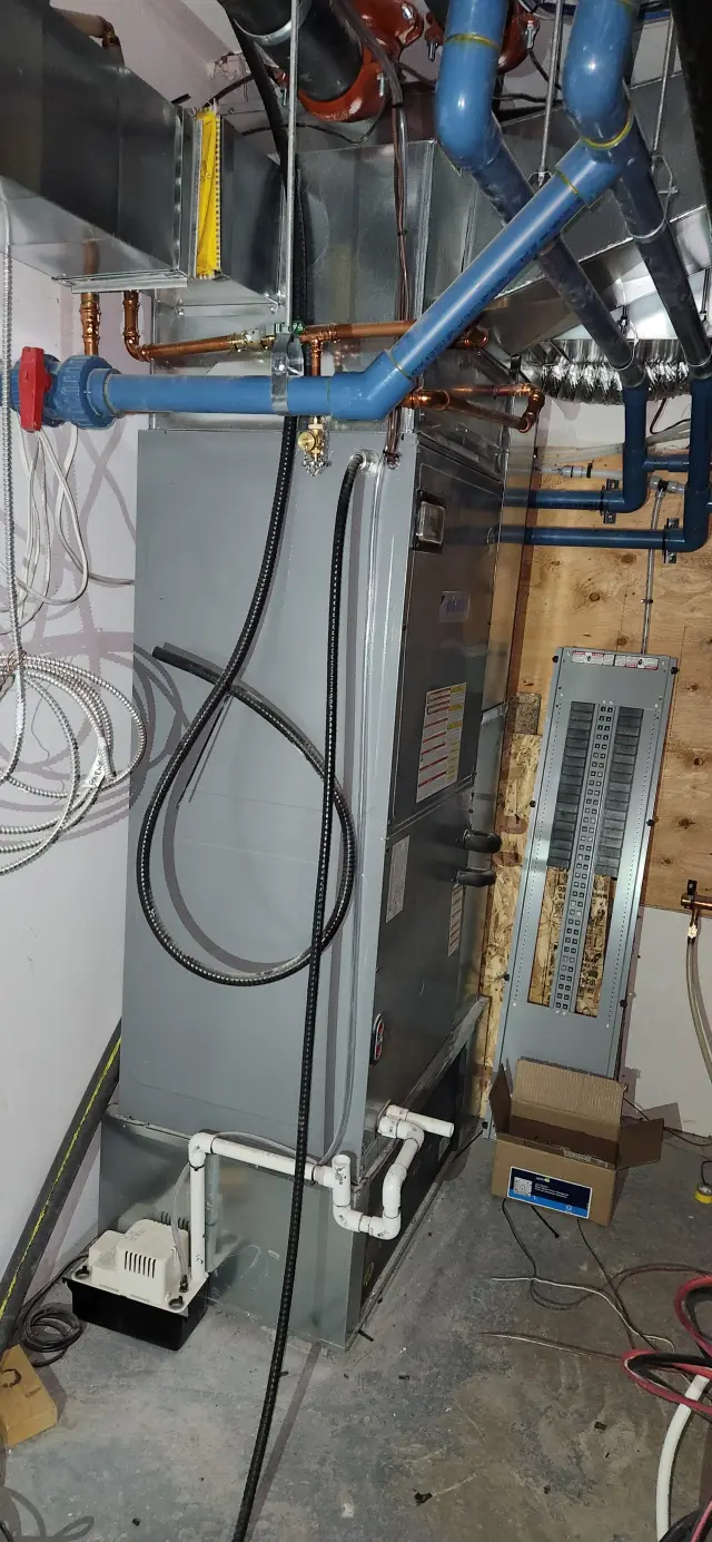 Image of an HVAC unit with blue piping and electrical wiring, showing the intricate details of the system's