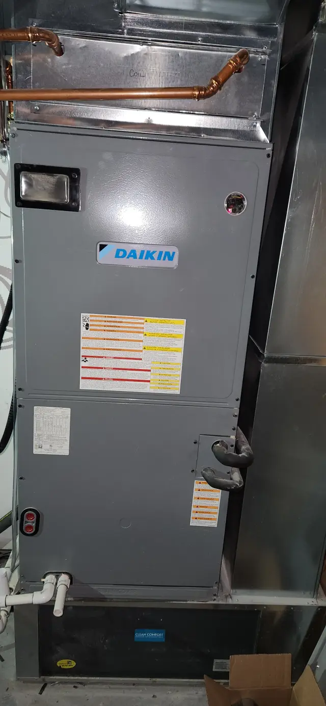 A Daikin HVAC unit with labels, instructions, and piping visible