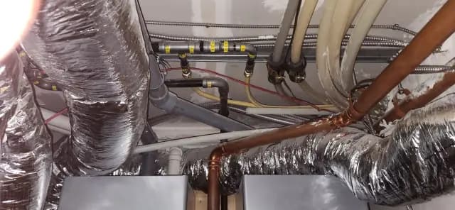 Ductwork with insulation wrapped around pipes