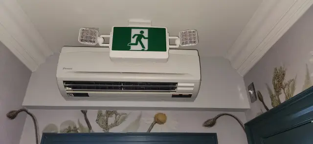 Air conditioning unit with emergency exit sign above it