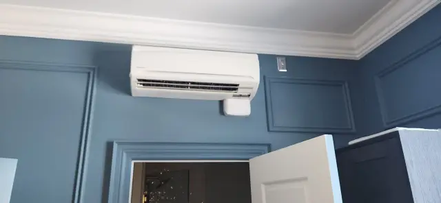 Air conditioning unit installed on a blue wall