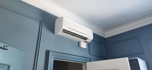 Air conditioning unit mounted on a blue wall