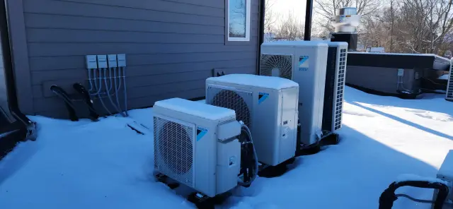Outdoor heat pump installed on roof with snow around