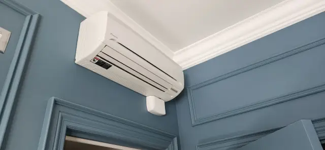 Air conditioning unit installed on a blue wall