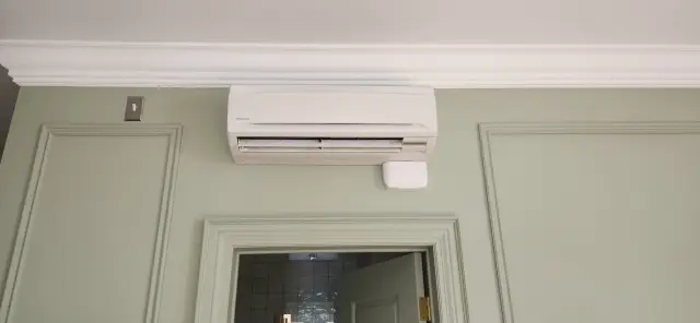 A technician is fitting an HVAC unit into a wall, highlighting the importance of proper installation in home comfort systems.