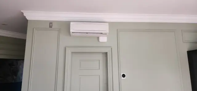 A new outdoor Gree heat pump is installed on the exterior wall of a house, with a clear