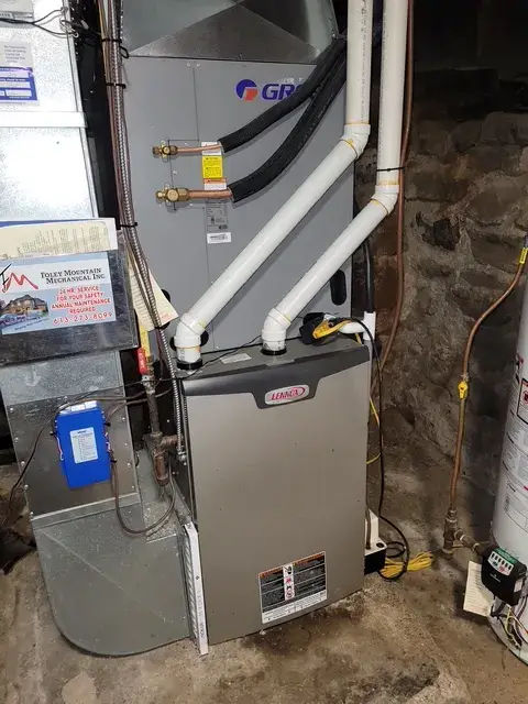 Outdoor Gree heat pump with white casing and blue logo, installed on concrete foundation