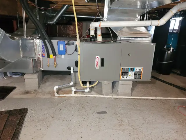 Outdoor Gree heat pump with its distinctive blue and white color scheme, installed on a concrete slab