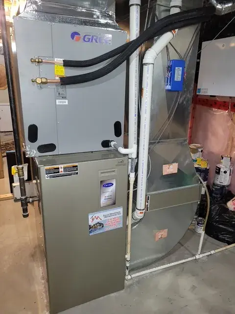 A new outdoor Gree heat pump is installed on a concrete surface with a metal framework. The unit