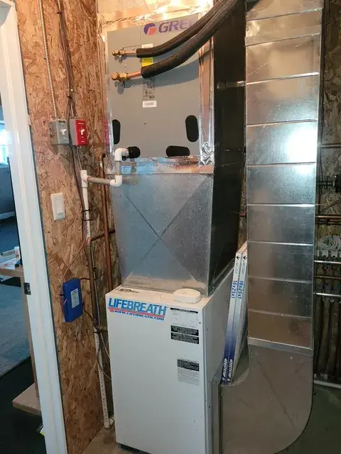 Outdoor heat pump with Gree branding, freshly installed on concrete foundation