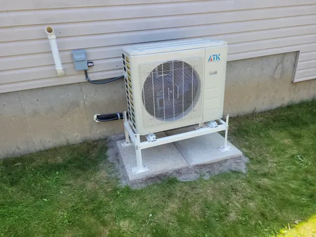 Outdoor Gree heat pump unit with large fan and condenser coil, installed on a platform with a concrete