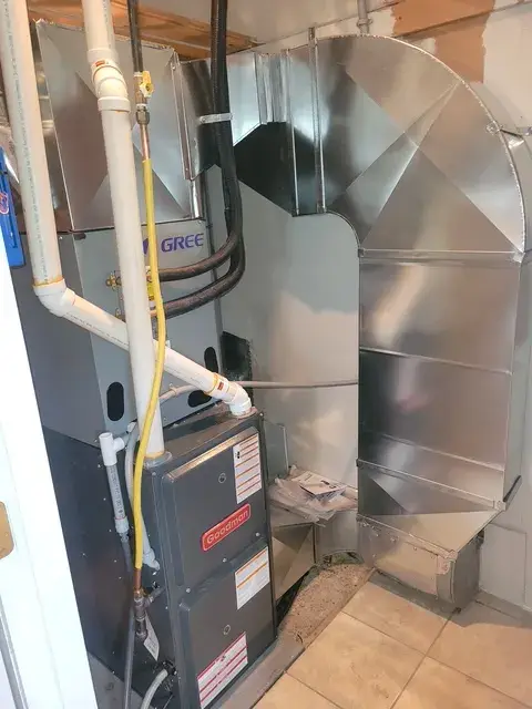 Outdoor heat pump with Gree branding installed on a concrete foundation