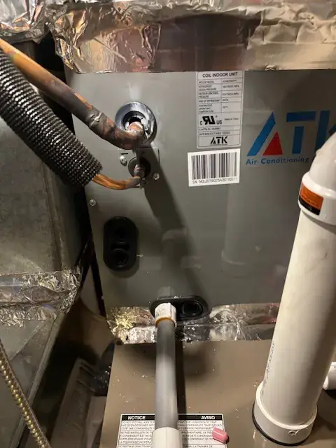 Outdoor Gree heat pump with copper refrigerant lines and protective insulation installed on concrete foundation