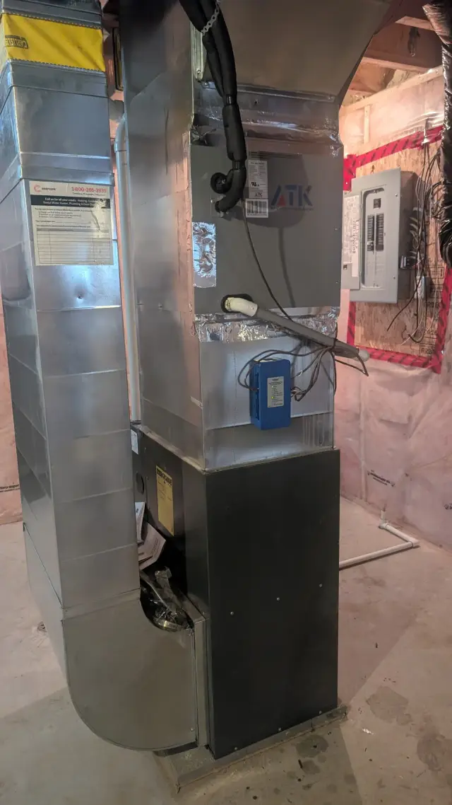 Outdoor Gree heat pump installed on concrete foundation with insulation around