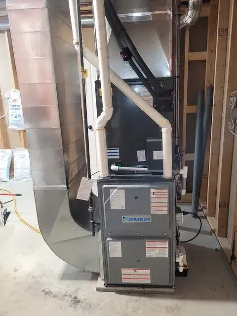 Outdoor Gree heat pump with white casing and black venting, installed on concrete foundation