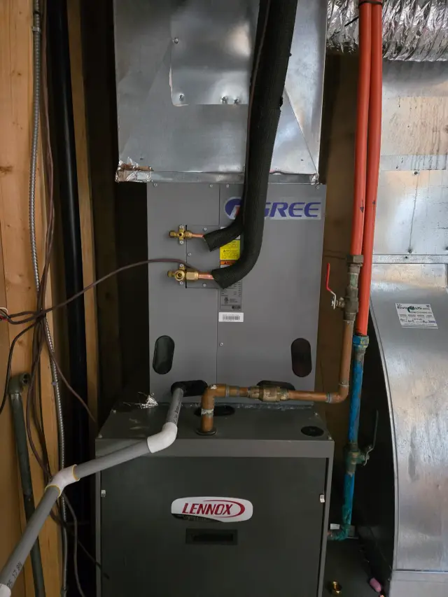 A Lennox furnace is installed in a home, with visible wiring and piping. The furnace is black with
