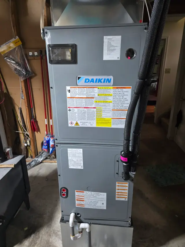 Outdoor Gree heat pump with a digital display, installed on a concrete slab