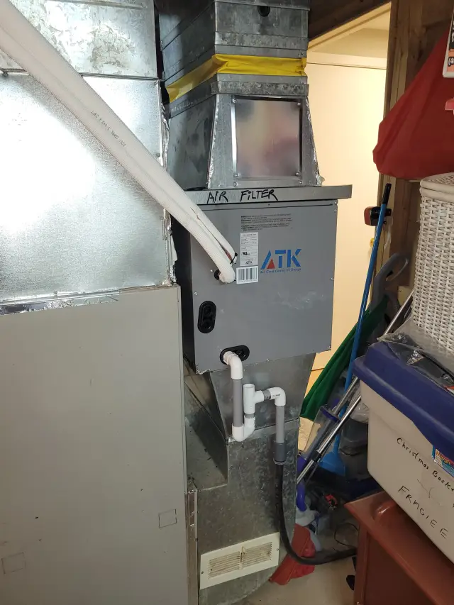 A silver metal air filter unit with a label reading 'ATK' and a yellow band around the top.