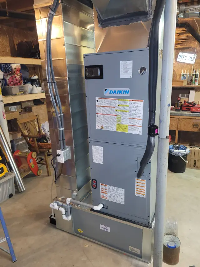 A Daikin furnace is installed in a basement with various tools and equipment around it