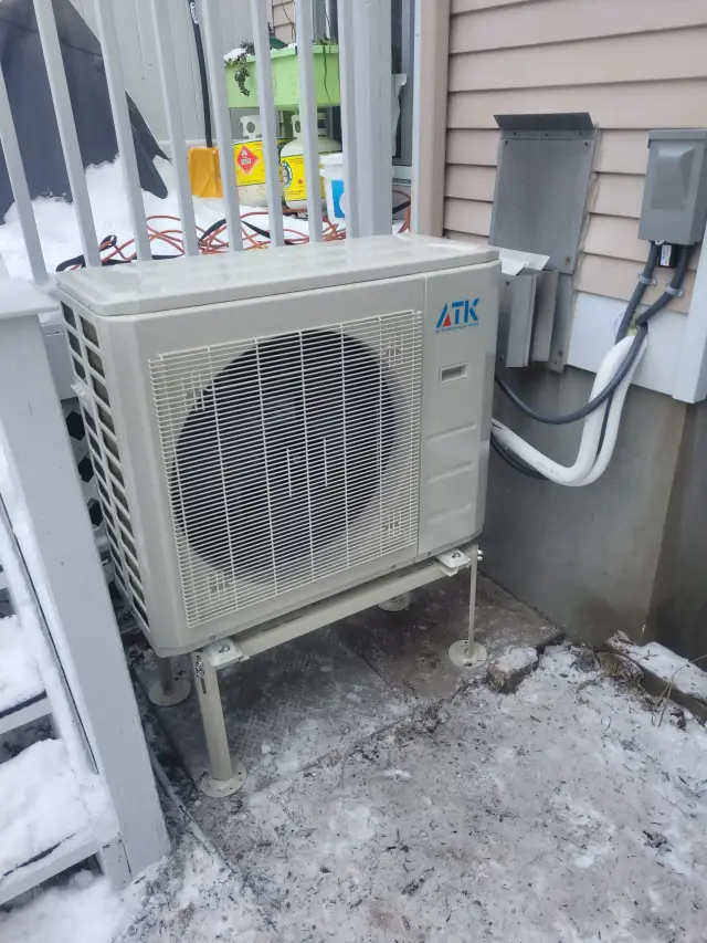 An outdoor heat pump unit with a large fan and the brand 'Gree' clearly visible is installed next