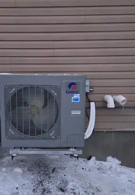 A large outdoor unit with a fan and the Gree logo is installed on the side of a