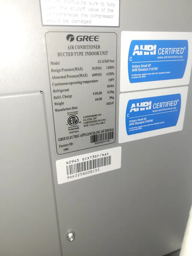 A close-up of the outdoor Gree heat pump unit, showing its gray casing and the brand logo prominently