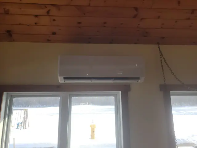 Outdoor Gree heat pump installed on exterior wall of house