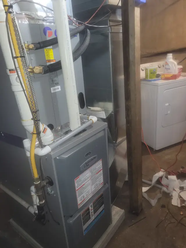 Outdoor Gree heat pump with white casing and yellow piping installed on concrete slab