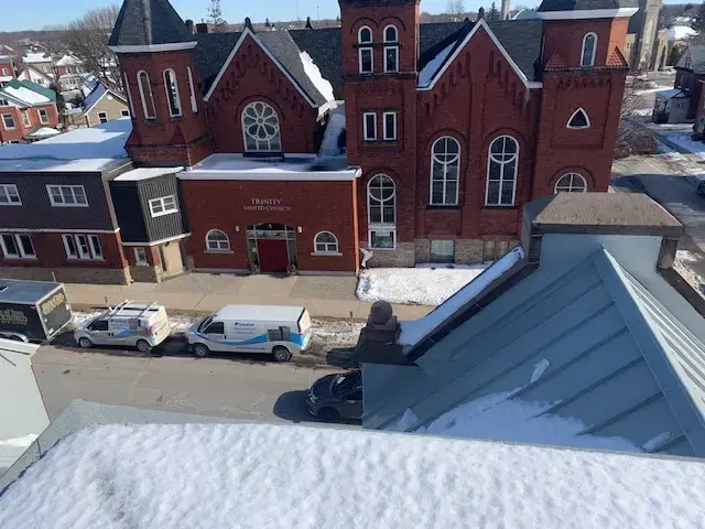 A newly installed outdoor Gree heat pump with a white casing and blue logo is placed on a