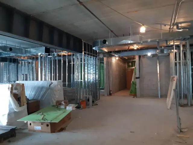 Metal studs and drywall in construction with tools and materials scattered around
