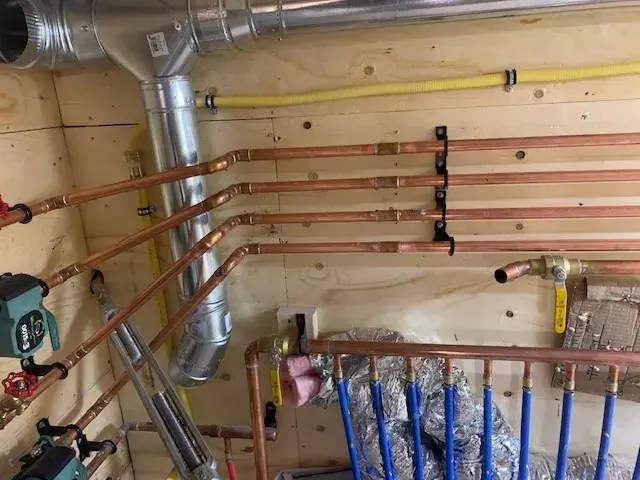 Copper pipes with valves, installed on a wooden wall