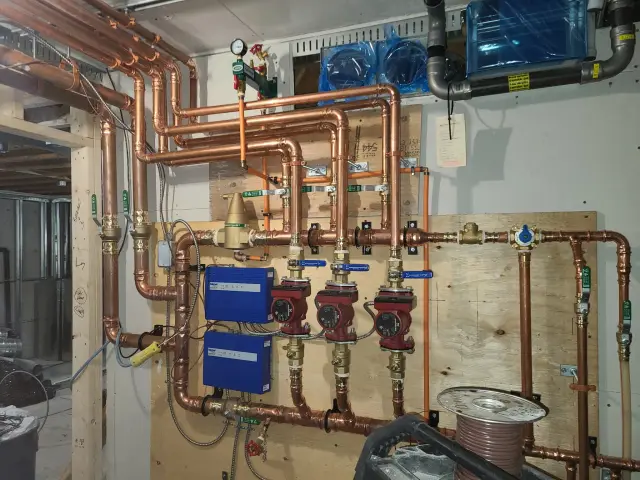 Copper pipes, valves, and gauges installed on a wall