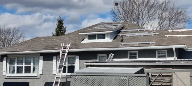 Solar panels are being installed on the roof of a house