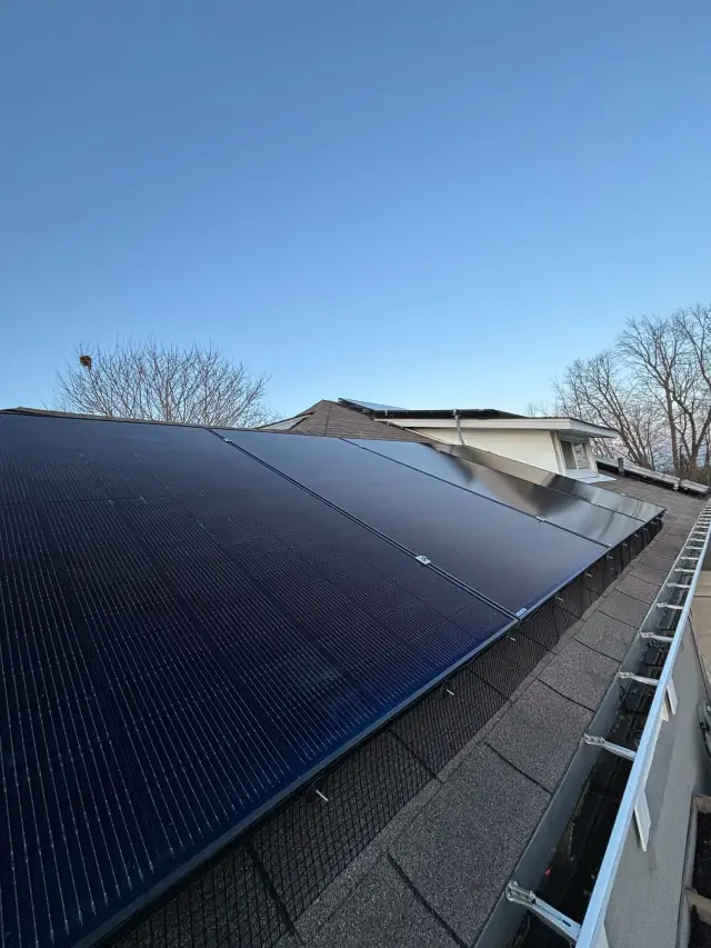 Solar panels on a roof with a clear blue sky in the background