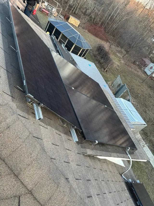 Solar panels on roof with metal framework and shingles
