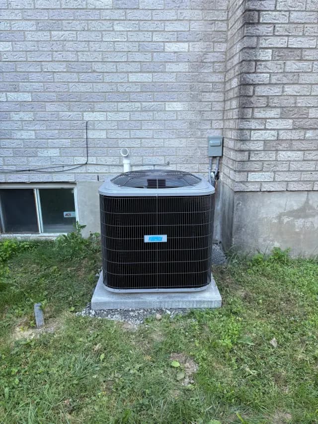 Outdoor Gree heat pump installed near brick wall