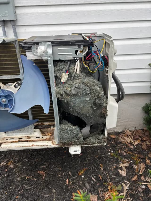 A newly installed outdoor Gree heat pump with a blue fan and a black casing is mounted on