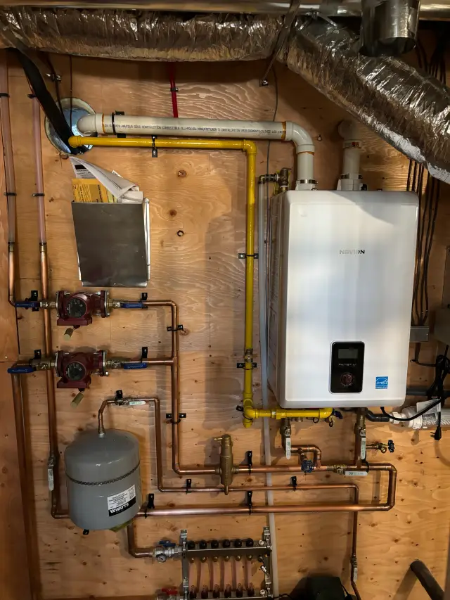Tankless water heater with digital display and piping connected to various fixtures