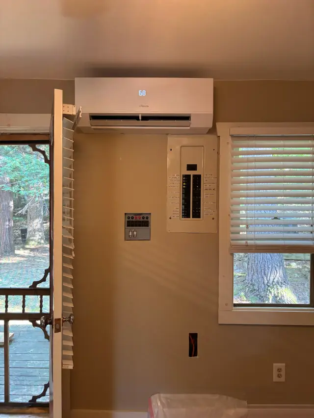 A new Gree heat pump is installed outside, with its sleek white casing and digital display showing the