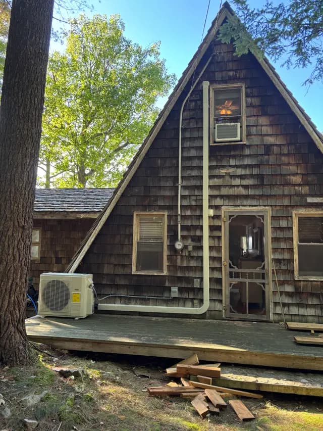 An outdoor Gree heat pump is installed on the side of a house, with a clear sky in