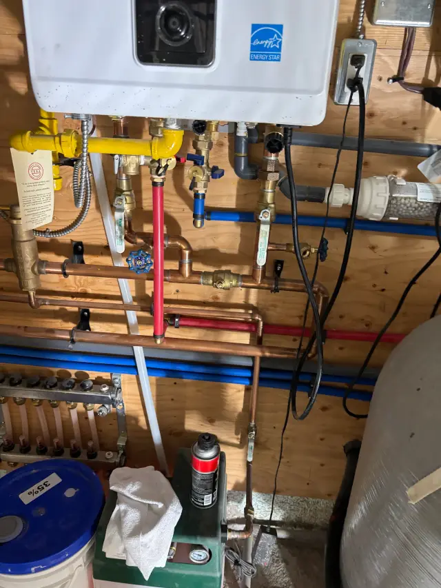 Radiant floor heat tubing is neatly laid out on insulation, ready for connection to the heating system