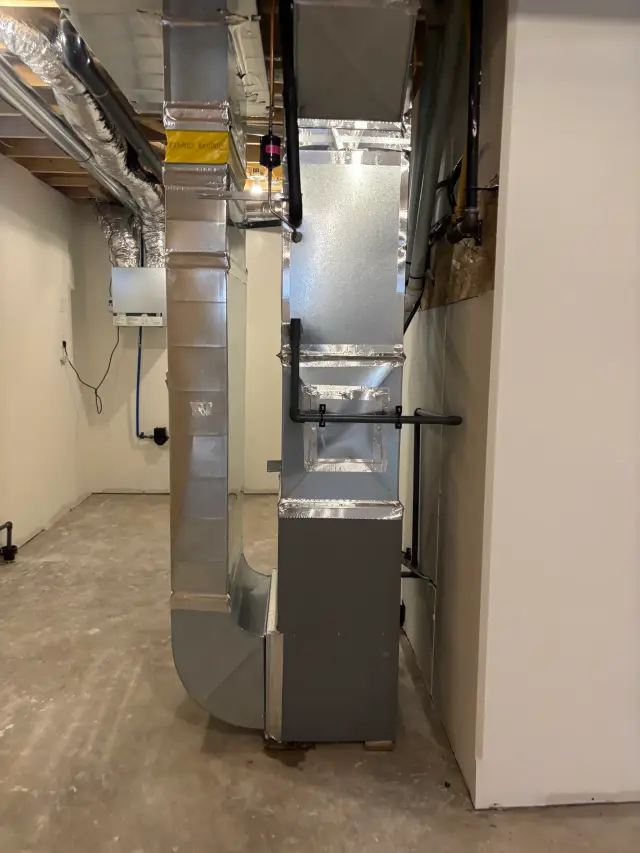 HVAC system components with silver insulation and black pipes