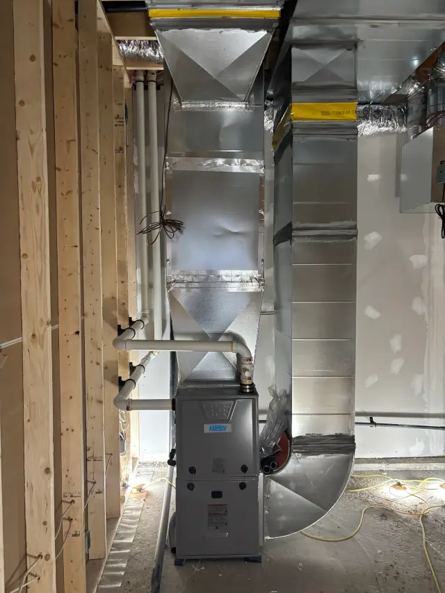 Ductwork installation with silver insulation panels and yellow sealing tape