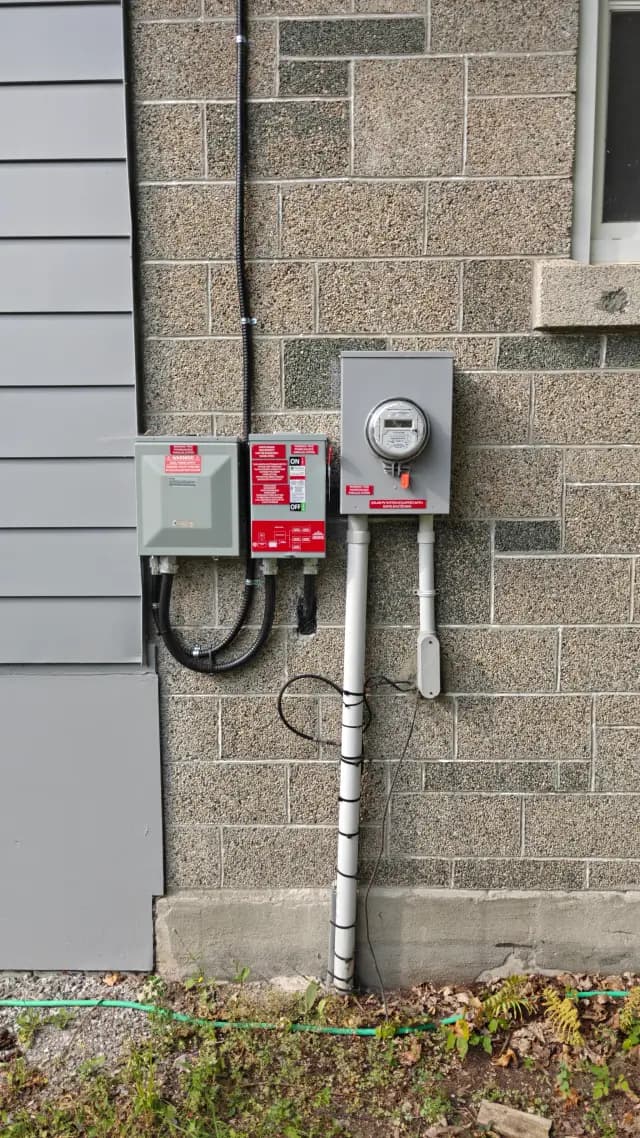 Outdoor Gree heat pump with a digital display, connected to electrical wiring and a gray electrical box, with